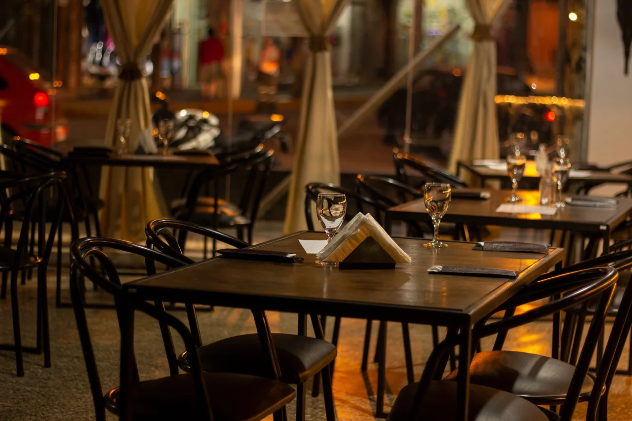 Warm wooden dining room with black chairs and wine glasses